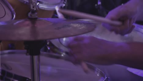 drummer plays percussion instruments at a concert as part of a musical group