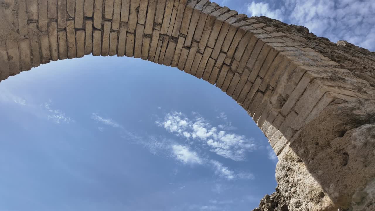 Stunning timelapse capturing light and shadow changes over an ancient Roman arched entrance, highlighting historic stonework and architectural detail