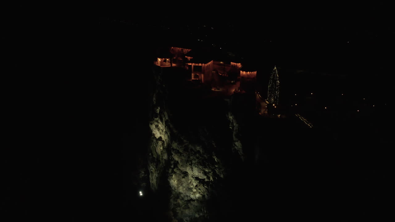 castillo sangrado en un acantilado iluminado por la noche