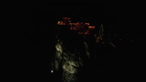 castillo sangrado en un acantilado iluminado por la noche