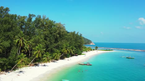 beautiful-peaceful-island-beach,-calm-turquoise-lagoon-with-mountain-jungle-in-the-background