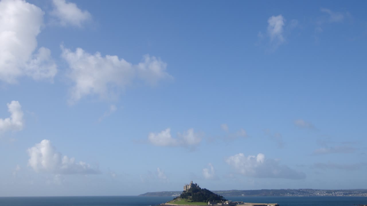 extra wide tilting down shot of St Michael's mount with the village of Marazion right of frame