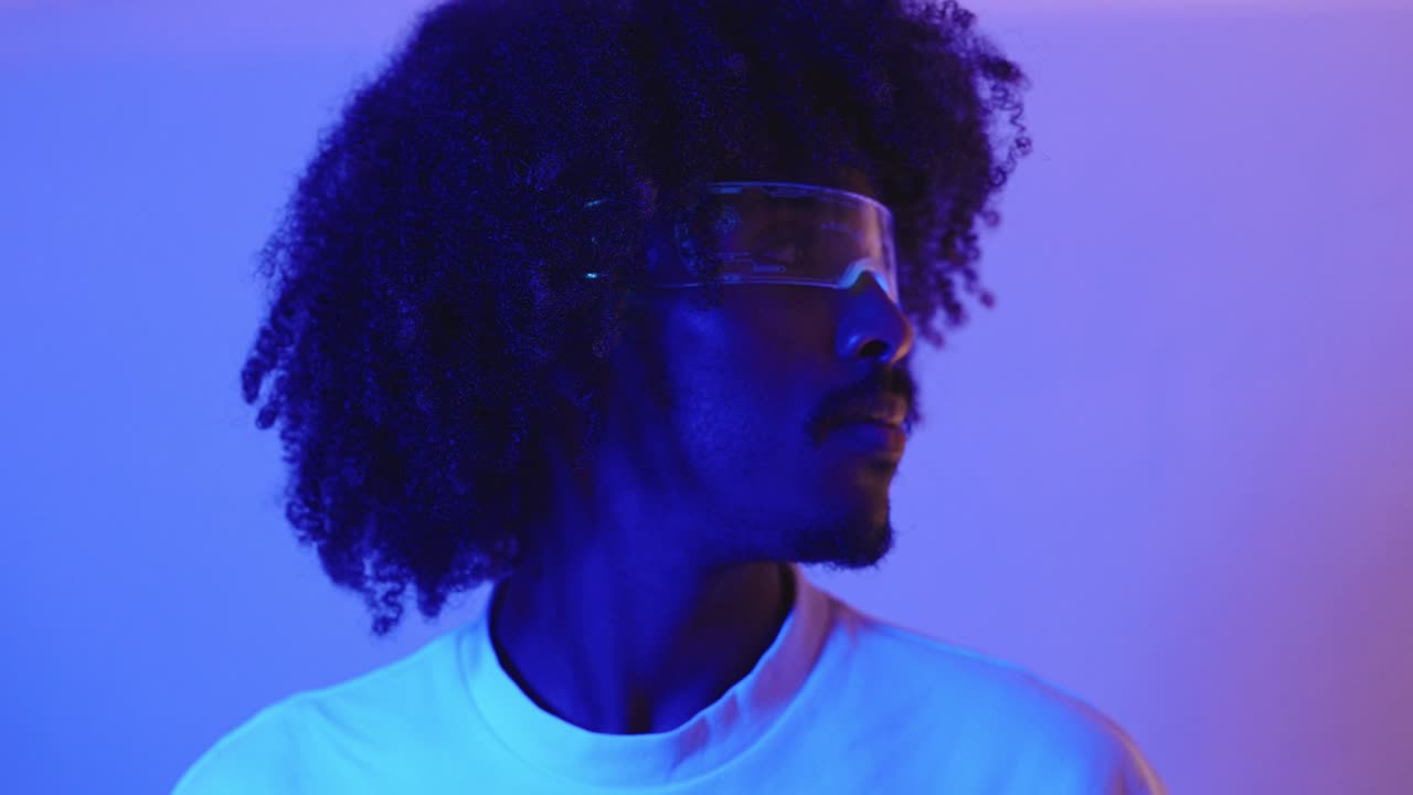 Man with Afro and Futuristic Glasses in Neon Lighting
