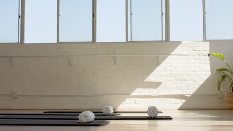 a yoga mat and towels are ready for class in a bright studio