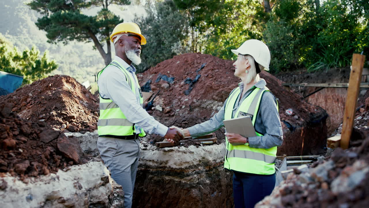 Construction workers shaking hands at a construction site