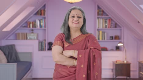 una anciana india feliz de pie con las manos cruzadas