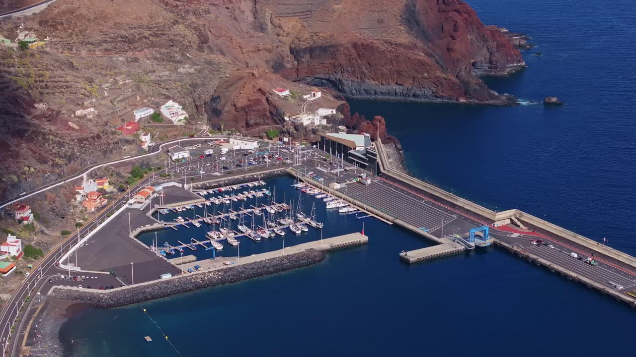 puerto de la estaca marina en el hierro, aguas azules tranquilas y acantilados volcánicos