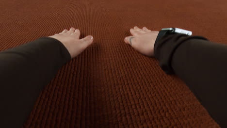 first-person perspective of hands and arms on a textured fabric surface