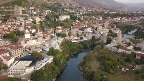 Toma-Aérea-De-Mostar-En-Bosnia-Y-Herzegovina,-Toma-Amplia-Del-Casco-Antiguo-De-Mostar-Con-El-Río-Neretva-En-El-Centro