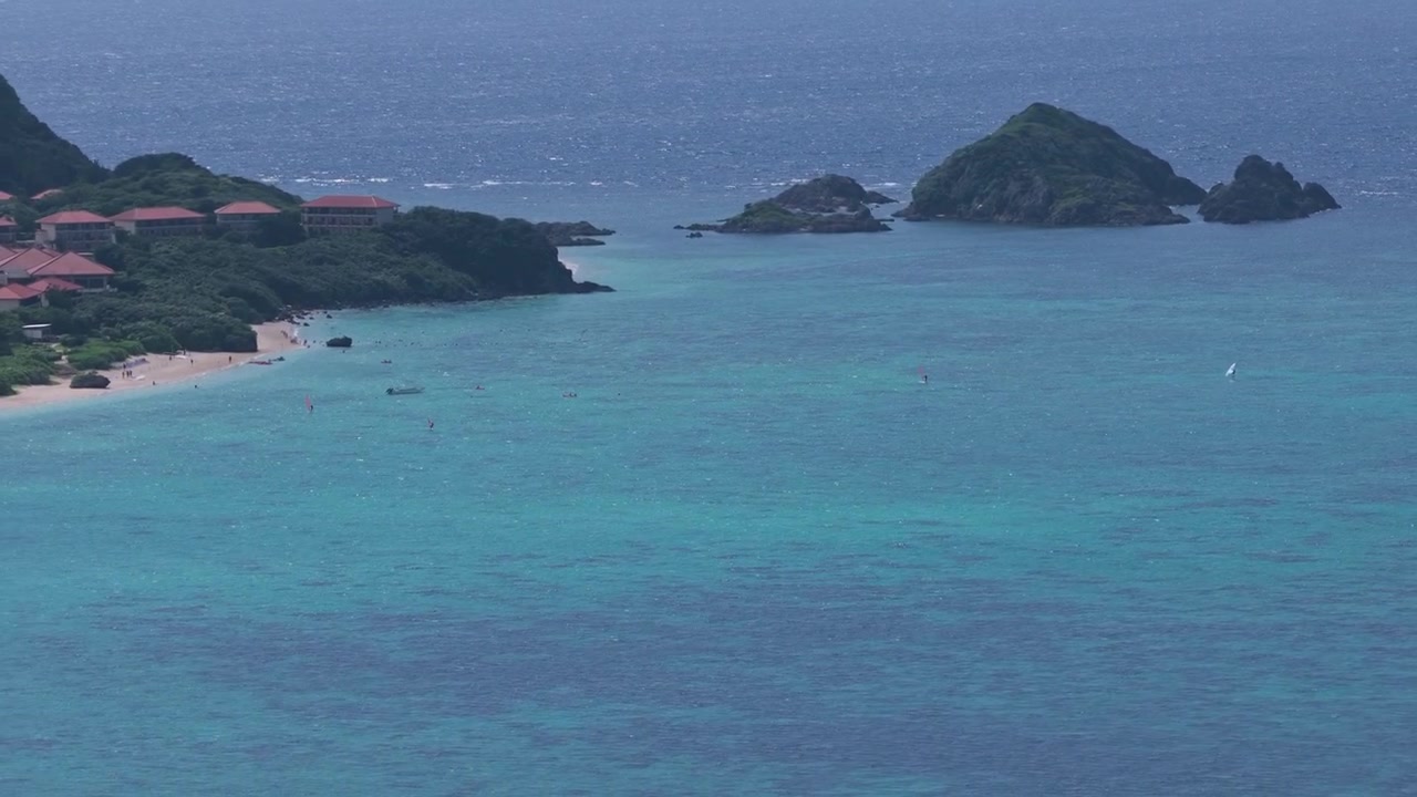 Riprese aeree orizzontali con movimento laterale a sinistra lungo le acque turchesi della Baia di Kabira vicino a Club Med e alla spiaggia di Tabaga, Isola di Ishigaki, Okinawa, Giappone