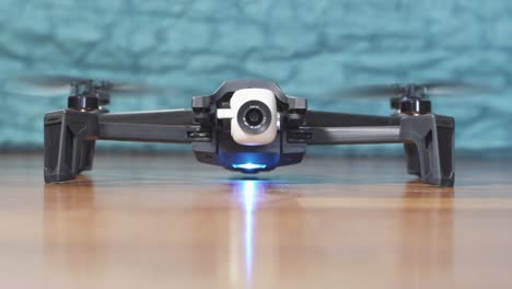 Launch-of-a-black-and-white-drone-on-parquet-floor-at-home-in-slow-motion