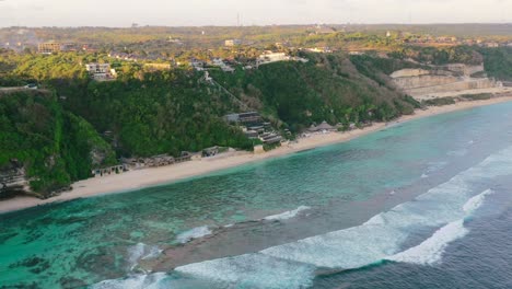 amplia costa de playa aérea de uluwatu con océano tropical en bali al atardecer