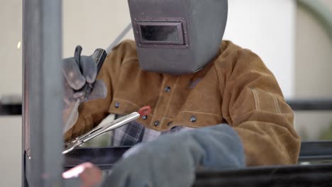 sparks from worker using stick welder, slow motion dolly right shot