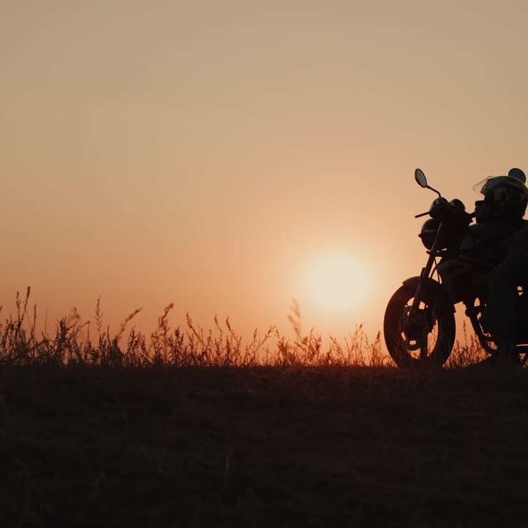 motorradfahrer hält an, um den wunderschönen sonnenuntergang zu bewundern