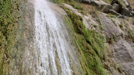 beautiful natural waterfall falling down the hills in mountains