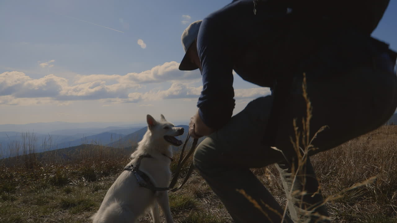 Backpacker and his dog at the top of the hill