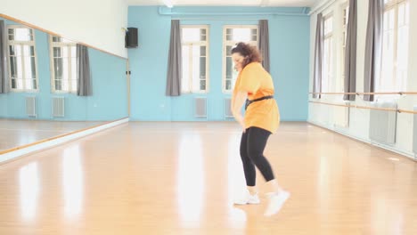 young brunette dancer practices her dance moves at the studio