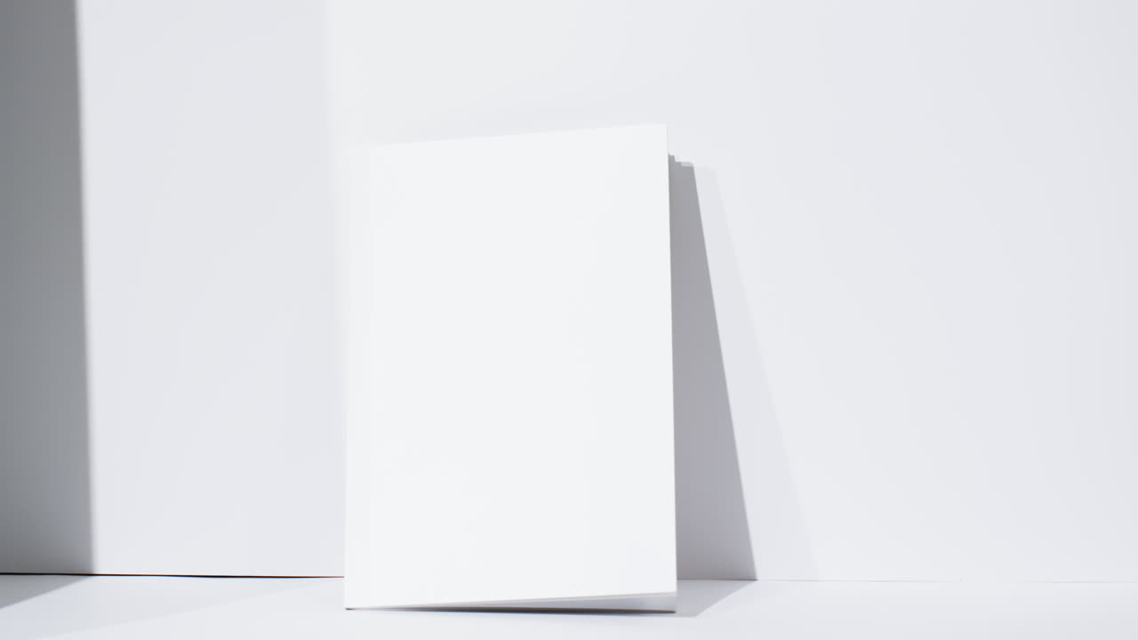 Video di un libro con pagine bianche vuote e spazio per il testo su sfondo bianco.