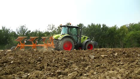 siguiendo un tractor agrícola que ara la tierra para prepararla para la próxima siembra