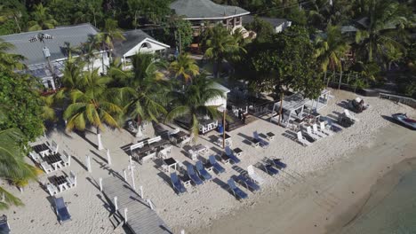 Vista-Aérea-Del-Encantador-Restaurante-De-Playa-Al-Aire-Libre,-West-Bay-Roatan