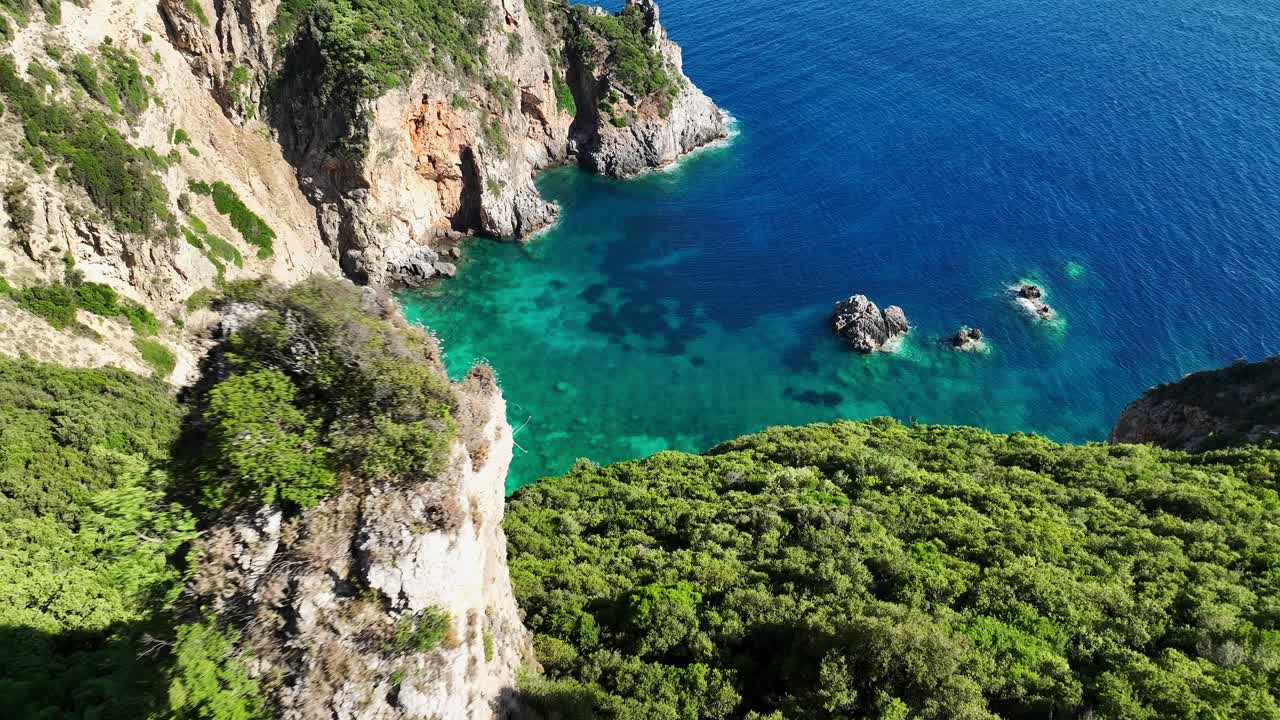 la playa de giali en la isla de corfú, aguas turquesas rodeadas de exuberantes acantilados, vista aérea