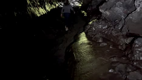 lady walking and exploring the kaumana cave in hawaii