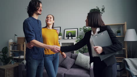 couple receiving keys to new home from real estate agent