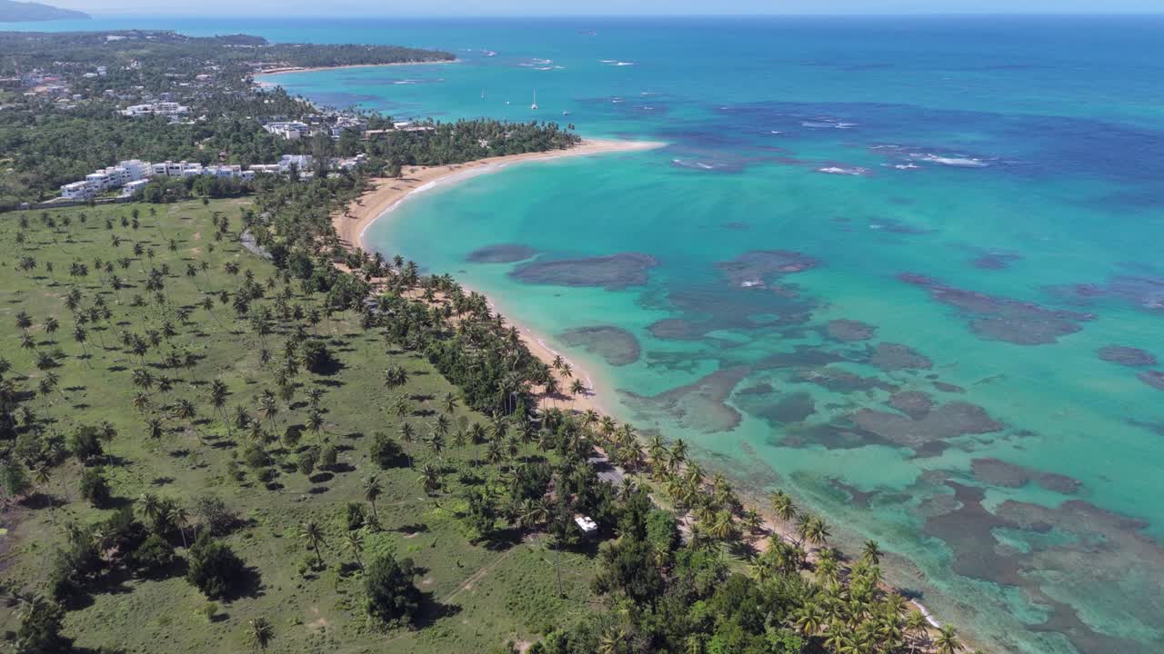Coral reef with turquoise water along sandy coastline. Aerial top down shot. Green forest landscape on island. PLAYA EL PORTILLO, LAS TERRENAS, SAMANA, Dominican Republic.