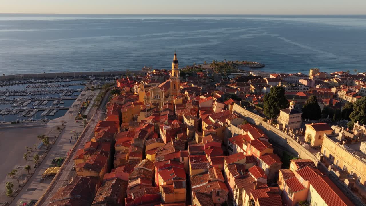 Tetti colorati e spiaggia al tramonto nel centro storico di Mentone, Francia