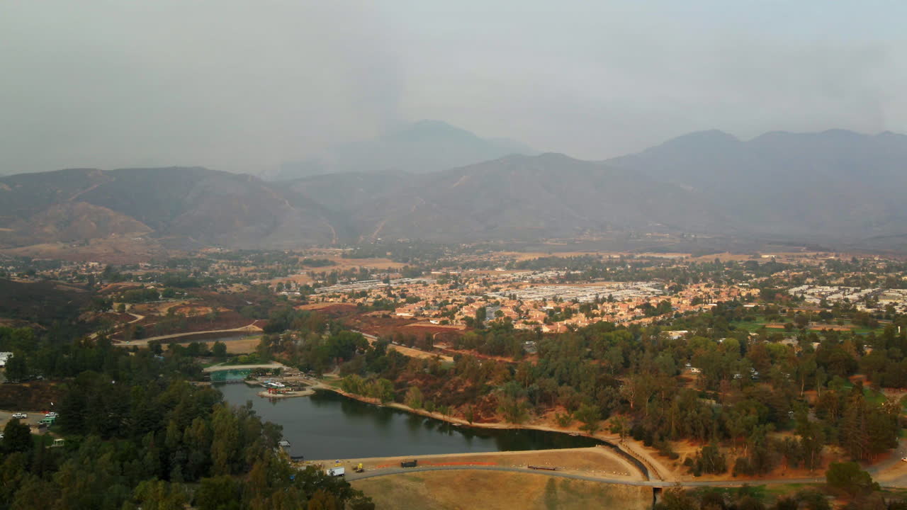 Hazy Aerial View of a Lake and Residential Area with Mountains in the Background