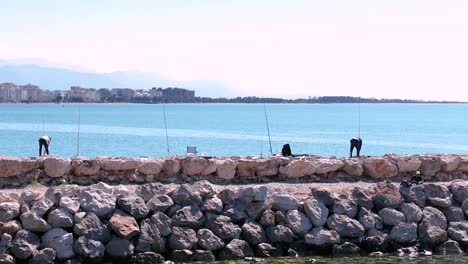 aerial pan of local fishermen prepping poles and lines from harbor jetty