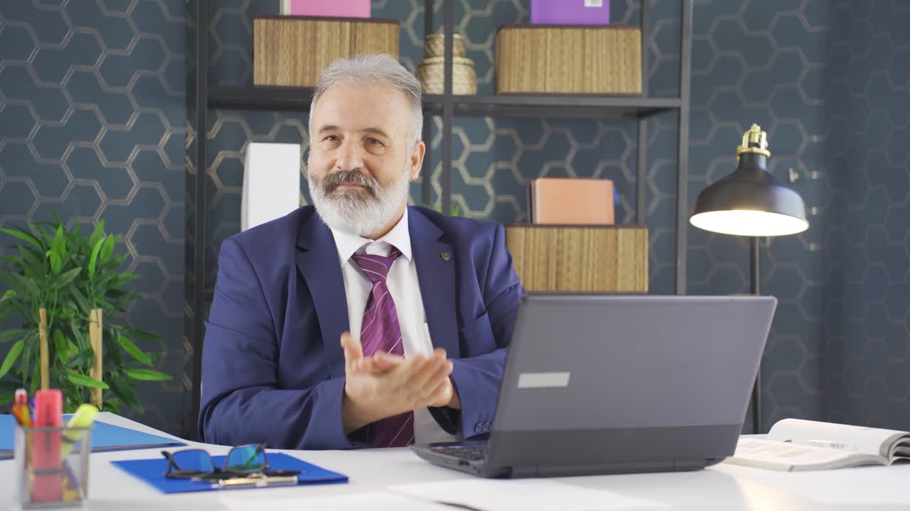 hombre de negocios aplaudiendo mientras mira a la cámara con orgullo y alegría.