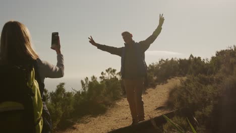 active senior couple taking picture in forest