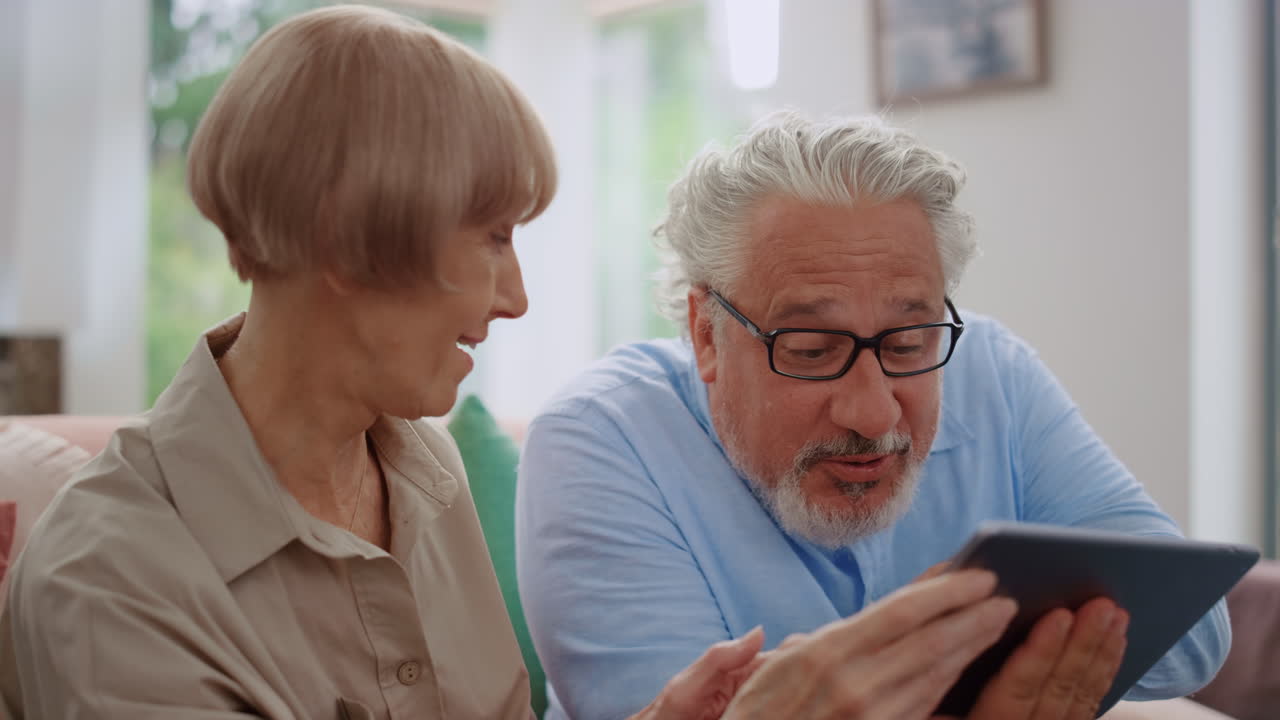 Uomo che guarda lo schermo del tablet con una donna. Nonni che usano il tablet per una videochiamata