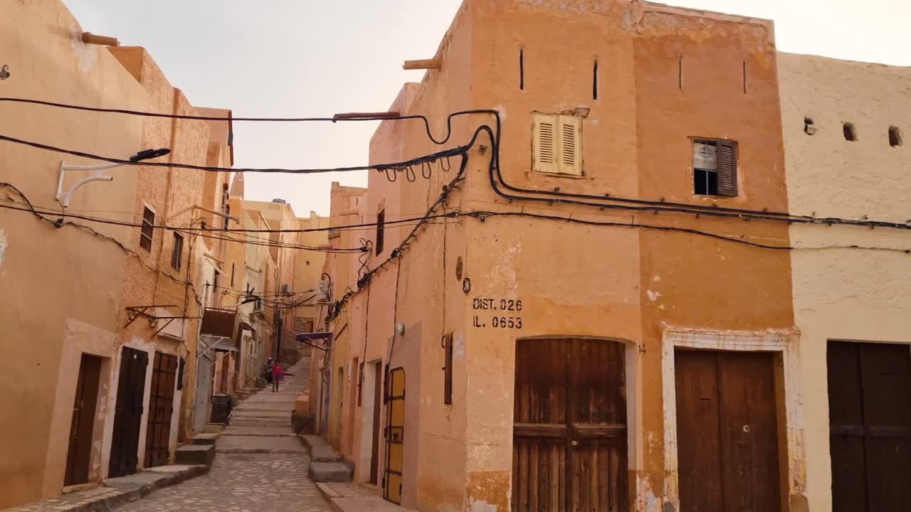 Shot in a quiet, narrow, paved alley with traditional clay houses and electrical installations in the old town of Ghardaia in Saharan desert of Algeria