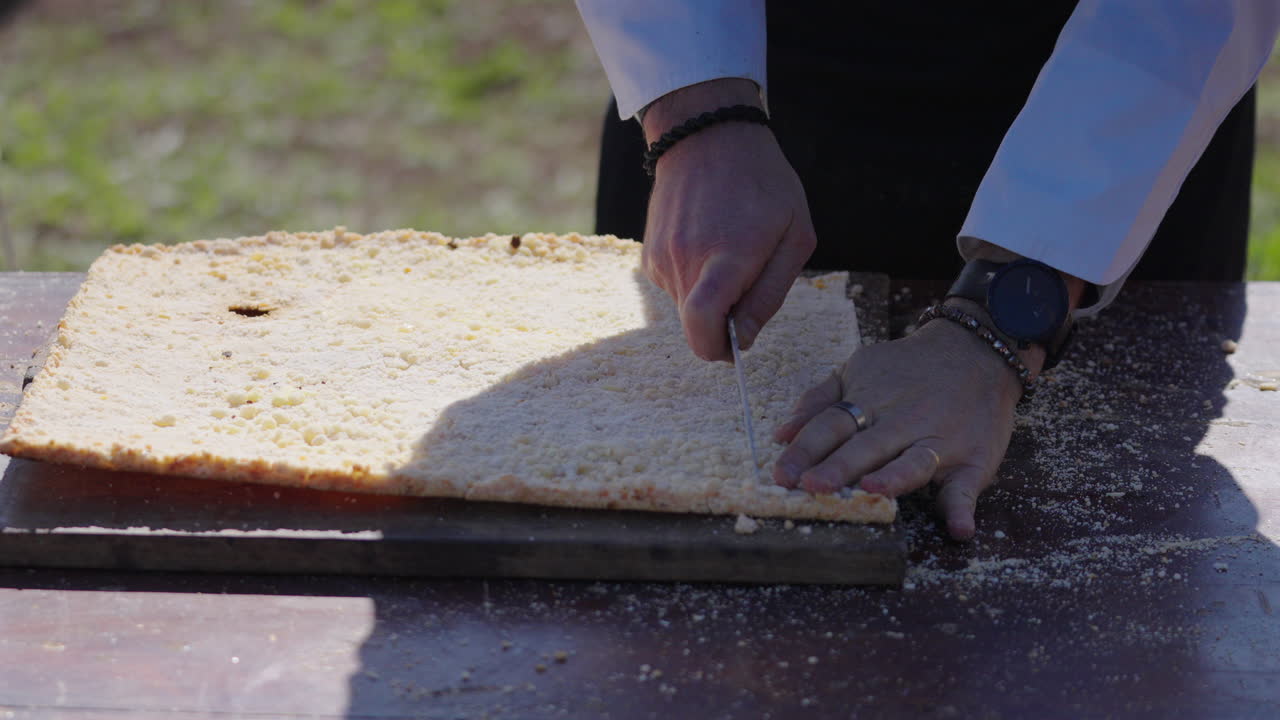 Chef cutting traditional Mbejú on wooden table, Paraguayan cuisine and food culture