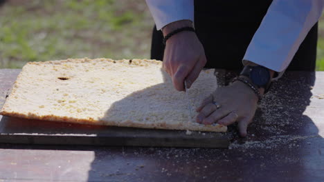 chef cutting traditional mbejú on wooden table, paraguayan cuisine and food culture