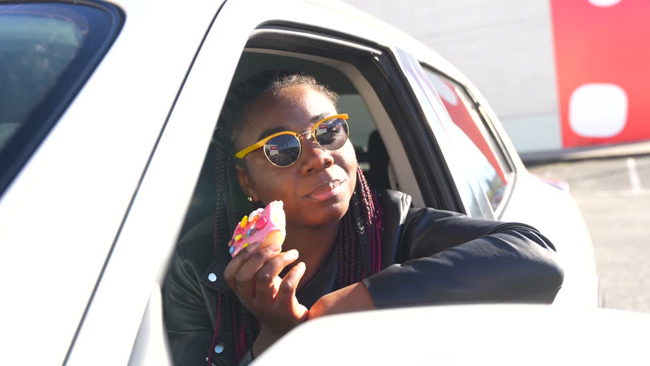 Woman eating a donut in her car