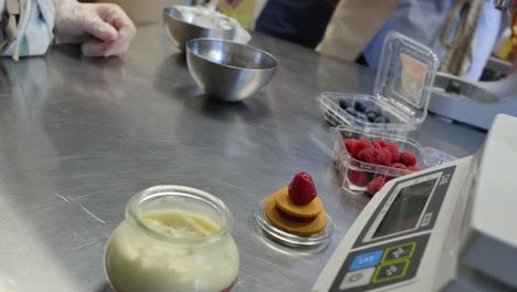 preparing a dessert with berries and cream