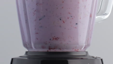 sliced fruits mixing milk in blender closeup. cocktail shake in slow motion.