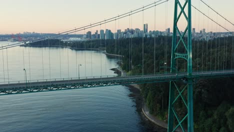 Increíble-Toma-Aérea-De-Un-Dron-Del-Puente-De-La-Puerta-De-Los-Leones-Con-El-Paisaje-Urbano-De-Vancouver-En-El-Fondo