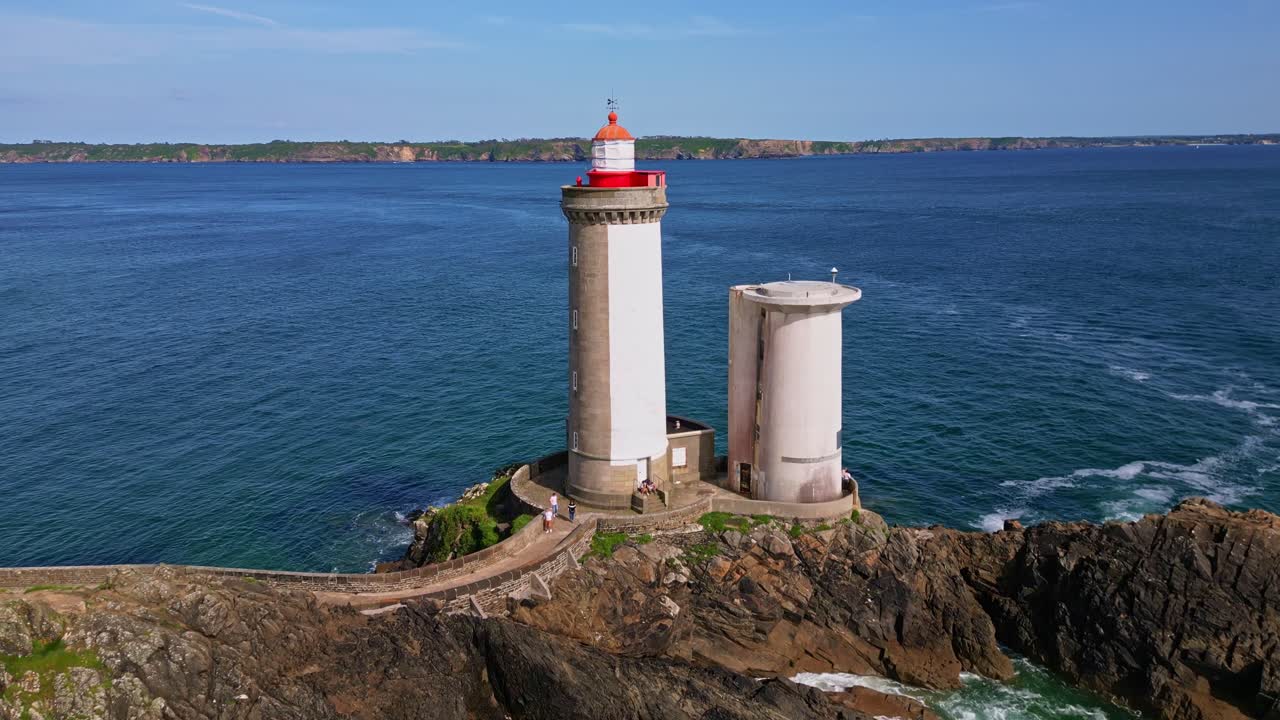 Iconic Petit Minou lighthouse standing tall on its rocky outcrop against vast blue sea highlighting its architectural details near the fort in Plouzané, Brittany, France, drone push in and close up