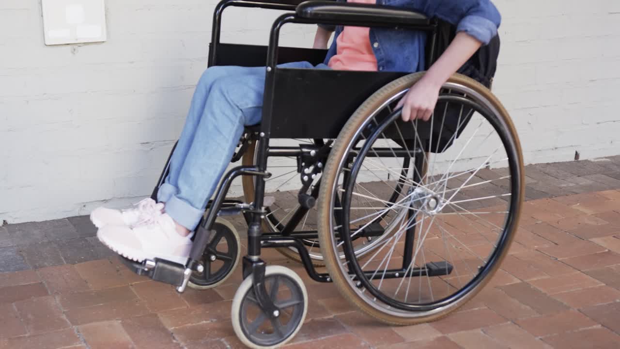La main droite pousse la jante, l’utilisateur de fauteuil roulant avance le long du couloir en briques pour continuer