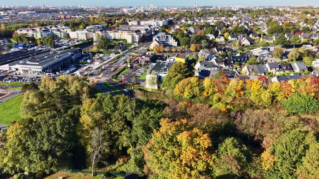 Aerial view of Cesson Sevigne shows the main axis of Rue de Rennes Route de Paris (D286), retail auto dealership zone, and surrounding residential blocks in autumn, Brittany, France