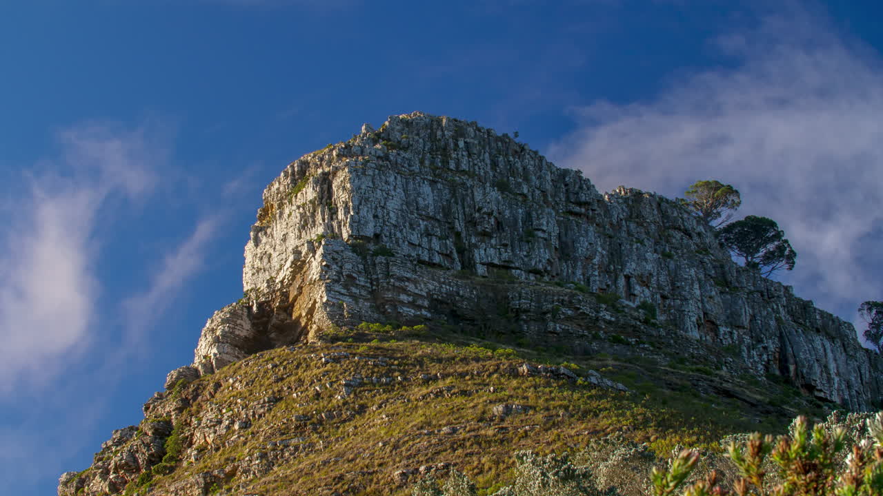 A rocky mountain landscape with a paraglider in the sky
