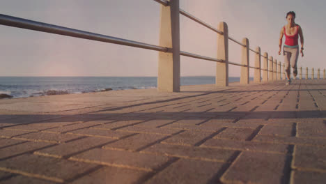 Spots-of-light-against-african-american-fit-woman-running-on-the-promenade