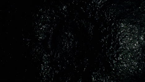 very slowly evolving, sparkly black shape as it moves towards the center