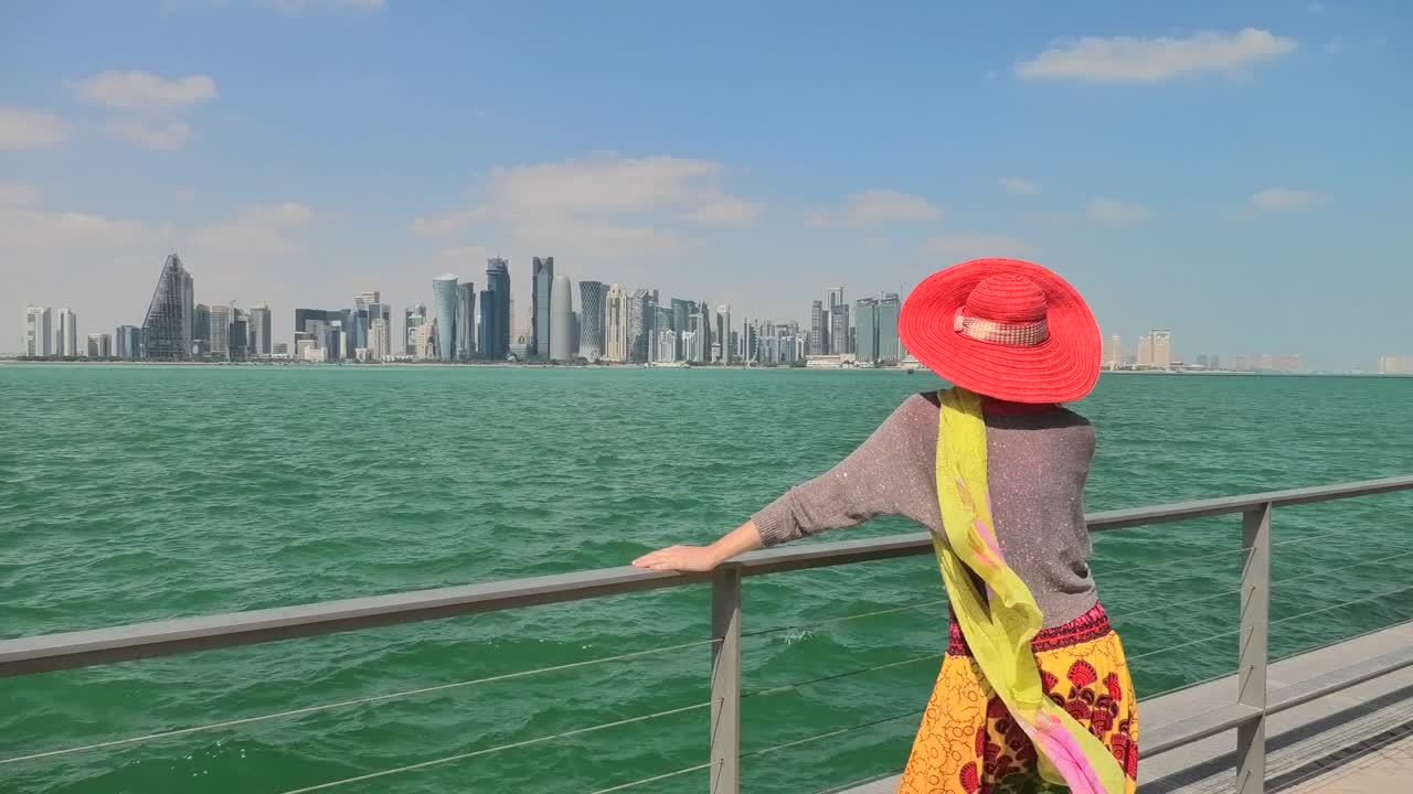 mujer por paisaje marítimo y paisaje urbano de doha