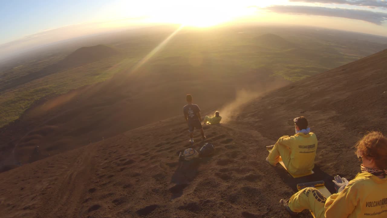Sandboarding down a volcano at sunrise