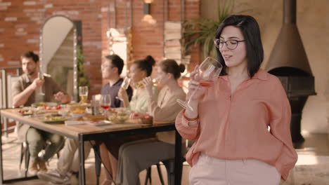 Una-Mujer-Joven-Bebiendo-Vino-En-Una-Cena